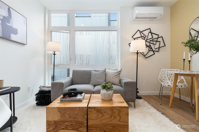 sitting room with hardwood / wood-style flooring and a wall mounted AC