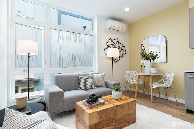 living room with an AC wall unit and light hardwood / wood-style flooring