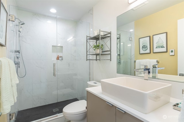 bathroom with vanity, a shower with shower door, and toilet