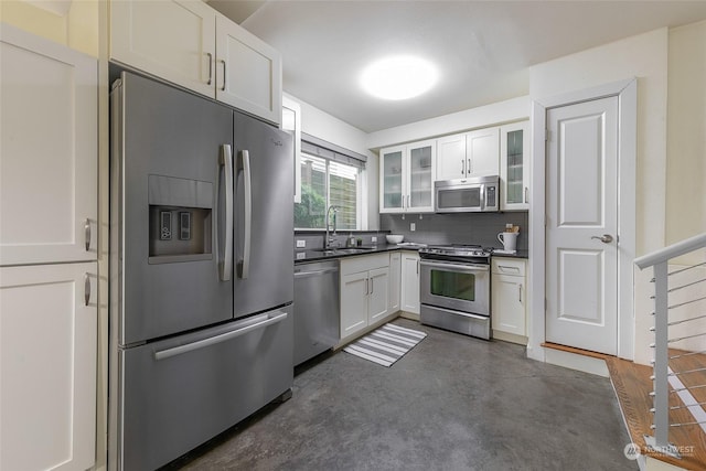 kitchen featuring appliances with stainless steel finishes, sink, white cabinets, and decorative backsplash