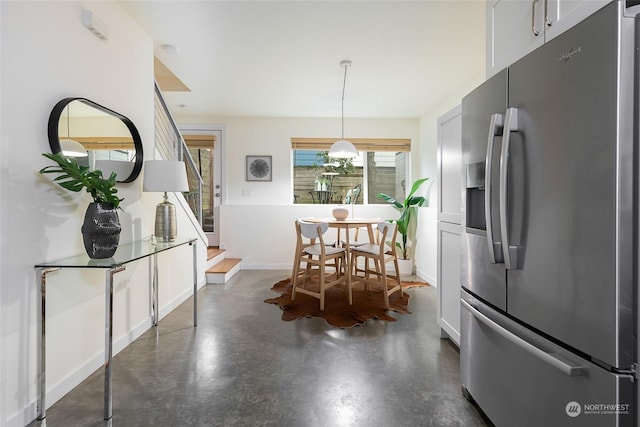 kitchen with white cabinetry, stainless steel fridge with ice dispenser, and hanging light fixtures