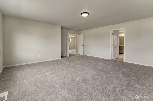 unfurnished bedroom with ensuite bathroom and light carpet