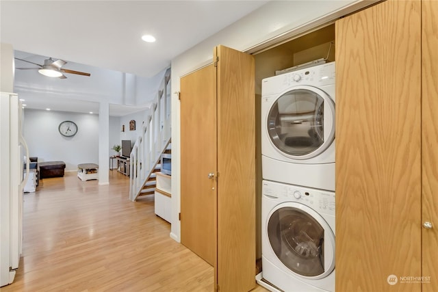 laundry area with ceiling fan, stacked washer / dryer, and light hardwood / wood-style flooring