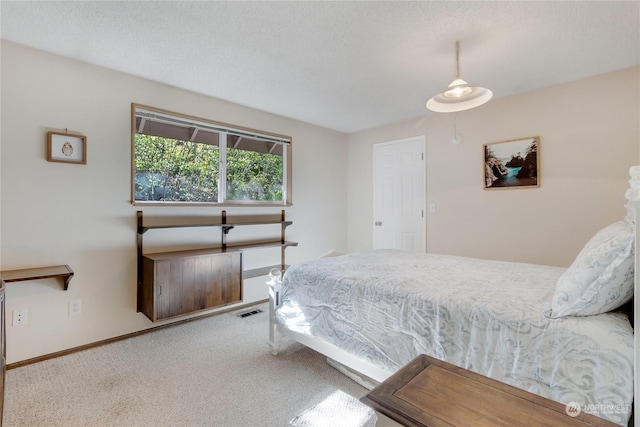 bedroom featuring carpet flooring and a textured ceiling