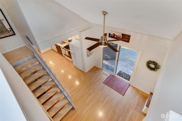 living room with ceiling fan, light hardwood / wood-style floors, and vaulted ceiling