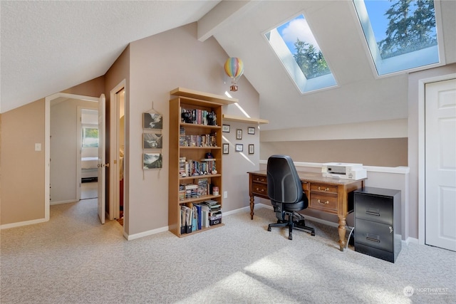 carpeted office with vaulted ceiling with skylight and a textured ceiling