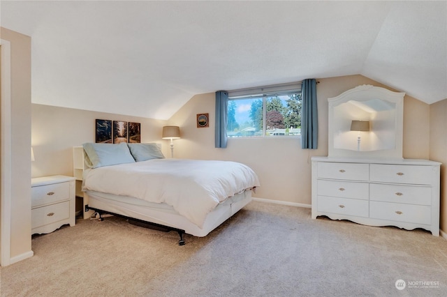 carpeted bedroom with lofted ceiling