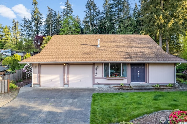 9230 119th St E, Puyallup, WA 98373 - view of front of house with fence, roof with shingles, an attached garage, a front lawn, and driveway