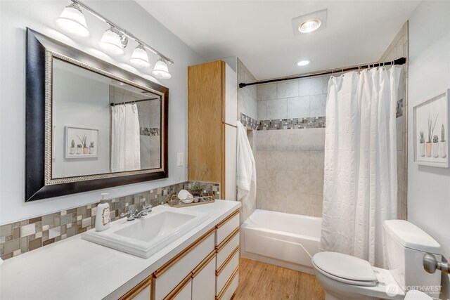 9230 119th St E, Puyallup, WA 98373 - full bathroom with shower / bath combination with curtain, tasteful backsplash, wood finished floors, vanity, and toilet