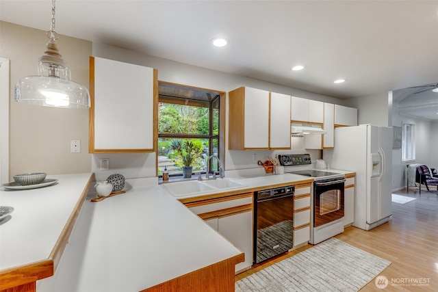 9230 119th St E, Puyallup, WA 98373 - kitchen featuring electric range oven, a sink, light countertops, under cabinet range hood, and black dishwasher