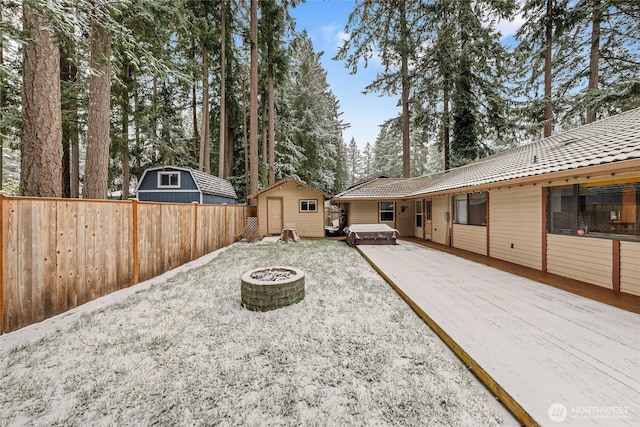 view of yard with a storage shed, a hot tub, a deck, and a fire pit