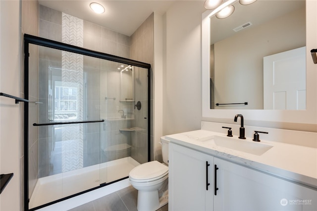 bathroom featuring a shower with door, vanity, and toilet