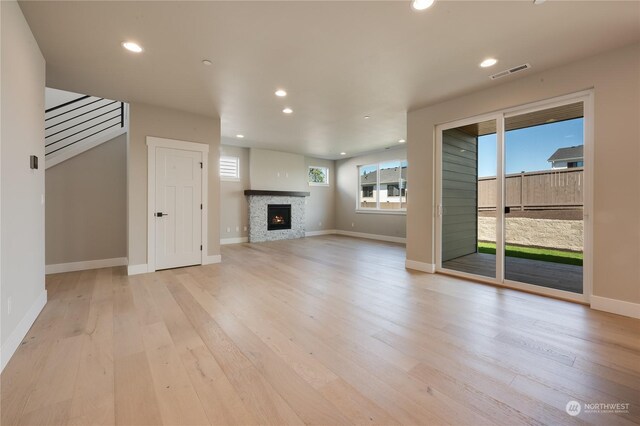 unfurnished living room featuring a fireplace and light hardwood / wood-style flooring