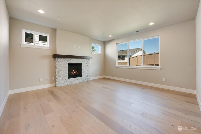 unfurnished living room featuring a fireplace and light wood-type flooring