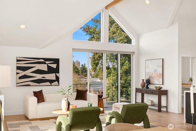 living room featuring light hardwood / wood-style floors, high vaulted ceiling, and beamed ceiling