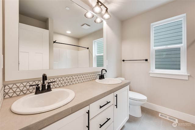 bathroom with walk in shower, tile patterned floors, toilet, vanity, and decorative backsplash