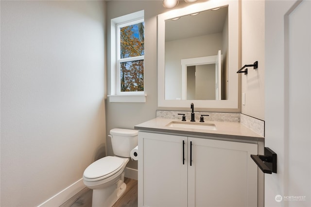 bathroom with hardwood / wood-style flooring, vanity, and toilet