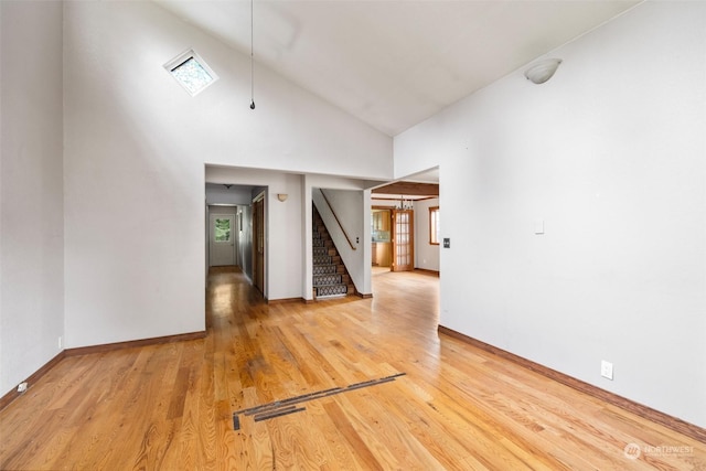 unfurnished room featuring hardwood / wood-style flooring and high vaulted ceiling