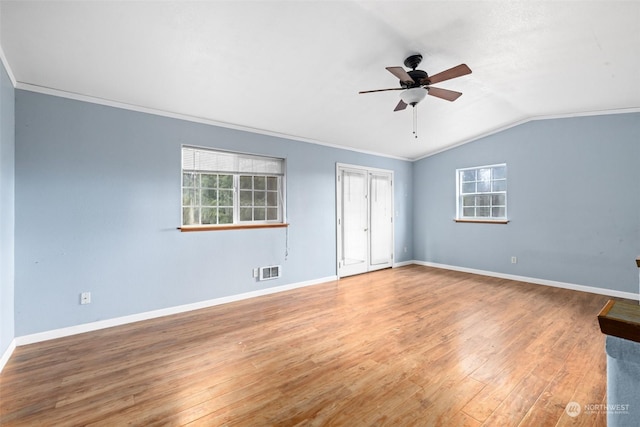 unfurnished room featuring lofted ceiling, hardwood / wood-style flooring, plenty of natural light, and ornamental molding