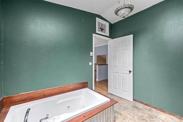 bathroom with vaulted ceiling and a bathtub