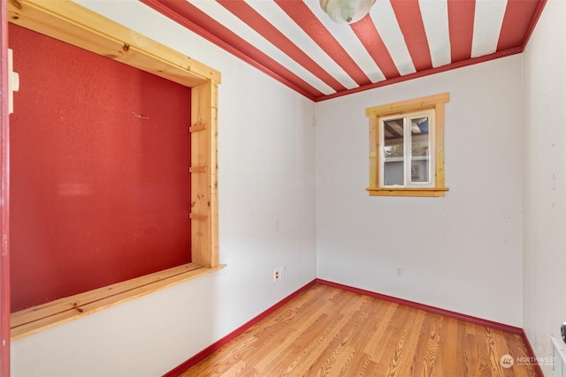 unfurnished room with ornamental molding and hardwood / wood-style floors