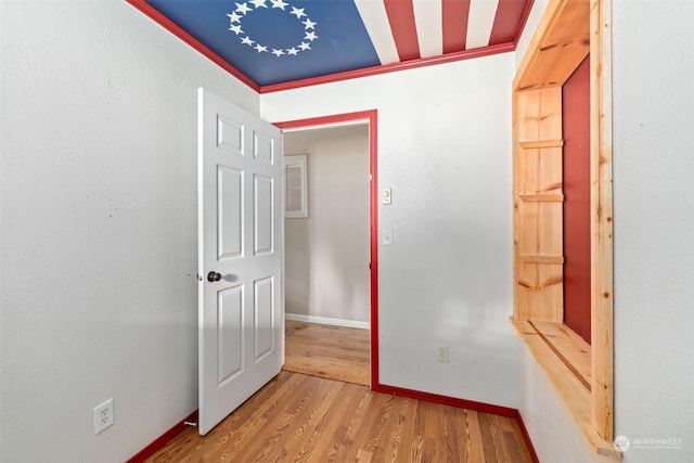 hall with ornamental molding and light wood-type flooring