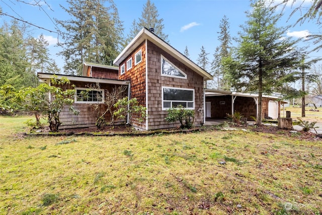 back of house featuring a carport and a yard