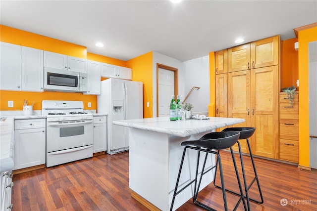 kitchen featuring white cabinetry, white appliances, dark wood-type flooring, and a kitchen island