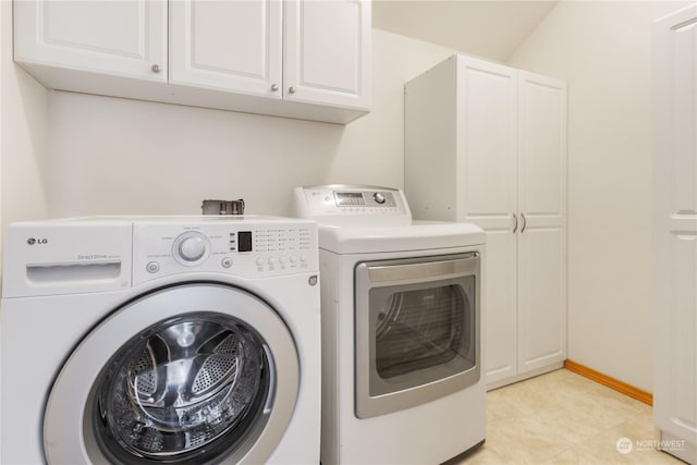 clothes washing area featuring cabinets and separate washer and dryer