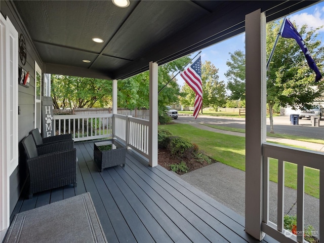 deck featuring a yard and covered porch