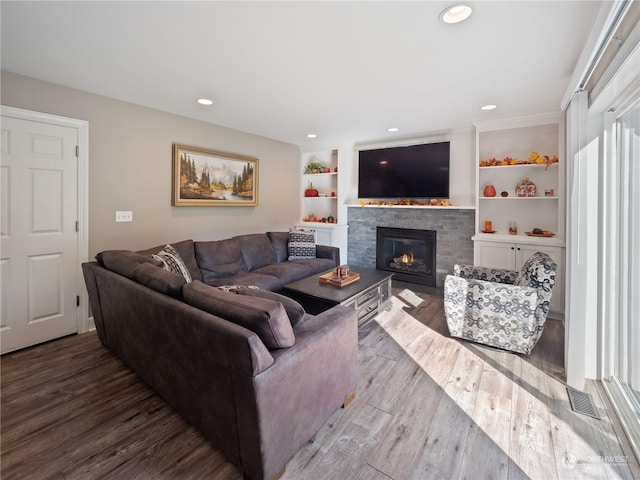 living room with dark wood-type flooring and built in shelves