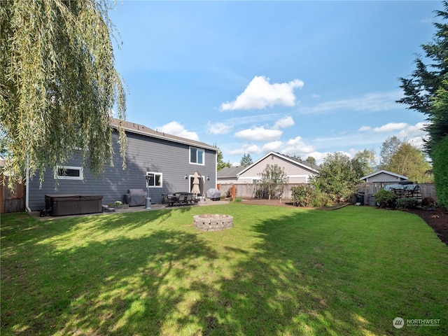 view of yard featuring a hot tub and an outdoor fire pit