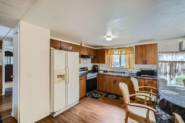 kitchen featuring stainless steel appliances, sink, wood-type flooring, and a textured ceiling