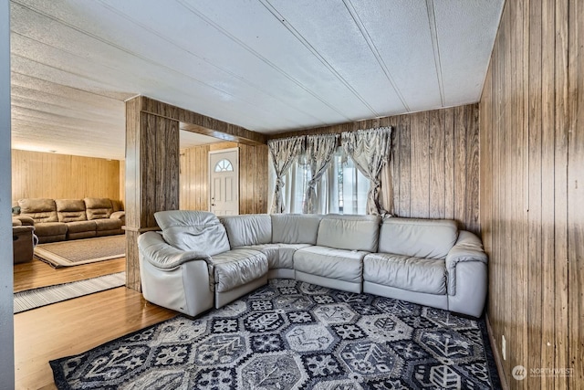 living room with wood-type flooring and wooden walls