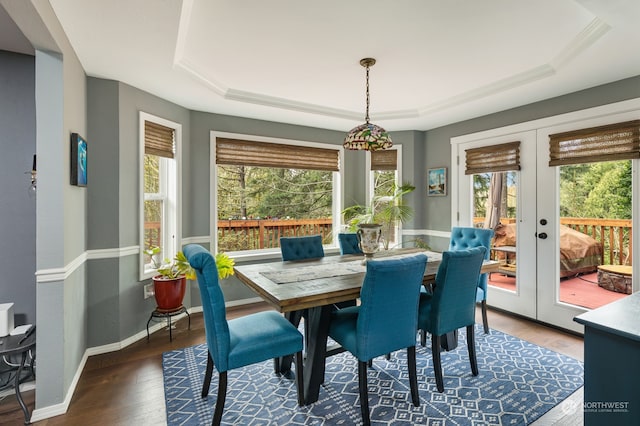 dining room featuring a raised ceiling, wood-type flooring, and french doors