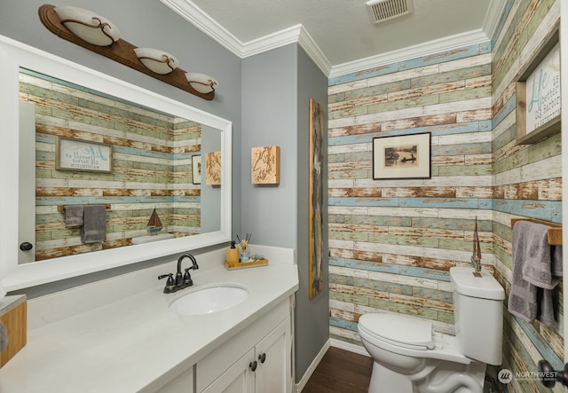 bathroom with vanity, wood-type flooring, ornamental molding, and toilet