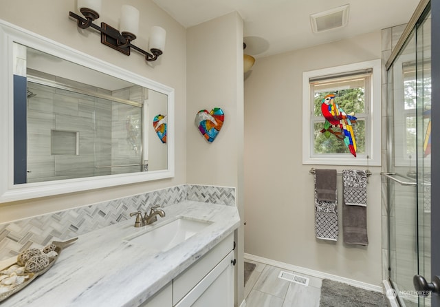 bathroom featuring vanity and an enclosed shower