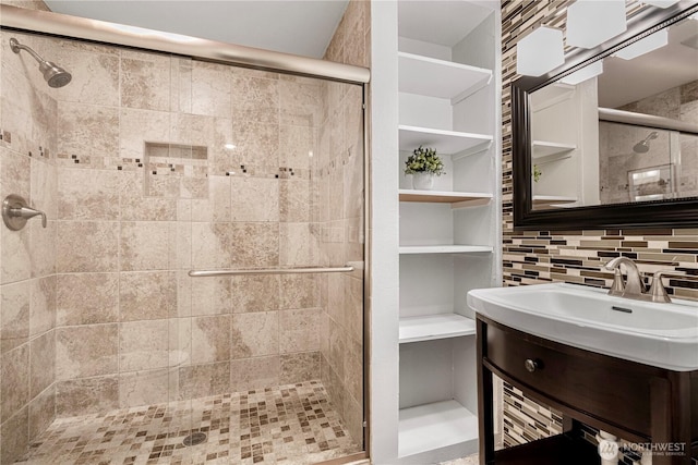 full bath featuring tasteful backsplash, a shower stall, and vanity