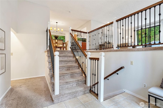 stairs with baseboards, tile patterned flooring, a textured ceiling, and an inviting chandelier