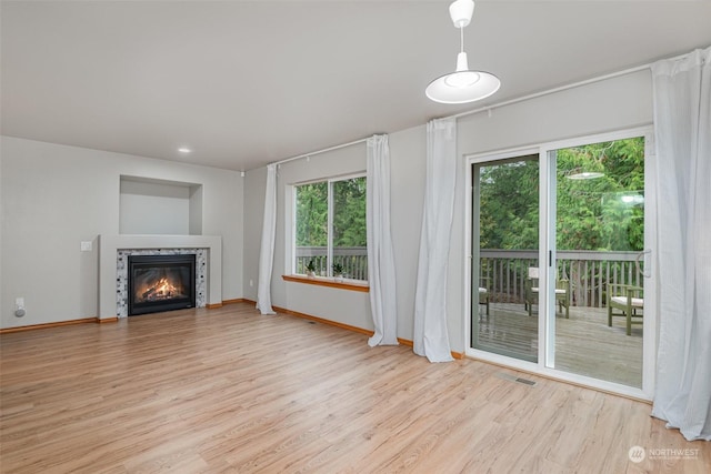 unfurnished living room featuring a healthy amount of sunlight and light wood-type flooring