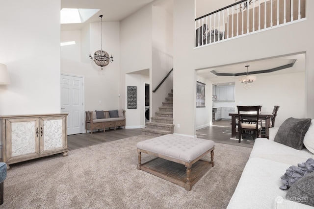 living room featuring a notable chandelier, hardwood / wood-style flooring, and a high ceiling