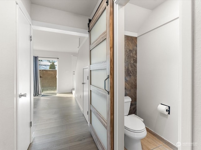 bathroom with hardwood / wood-style flooring and toilet