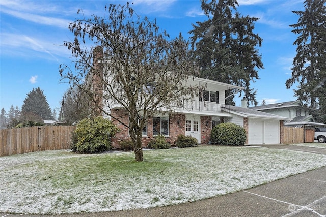 view of front of property featuring a garage, a front lawn, and a balcony