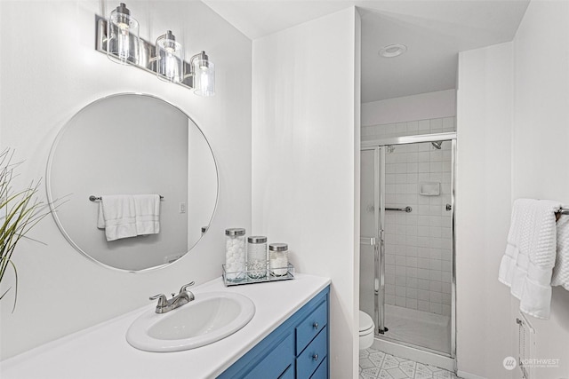 bathroom featuring vanity, toilet, and a shower with door