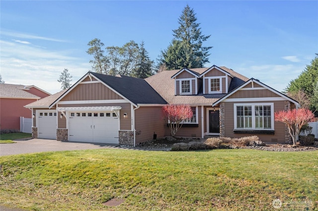 craftsman-style house featuring a shingled roof, an attached garage, a front yard, stone siding, and driveway