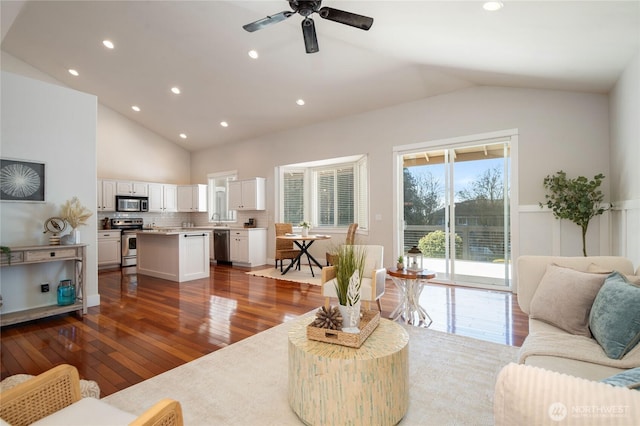 living area with hardwood / wood-style flooring, ceiling fan, high vaulted ceiling, and recessed lighting