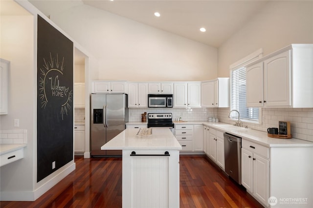 kitchen with dark wood-style floors, appliances with stainless steel finishes, white cabinets, and a sink