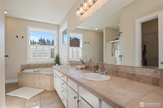 full bathroom featuring double vanity, tile patterned floors, a garden tub, a shower stall, and a sink