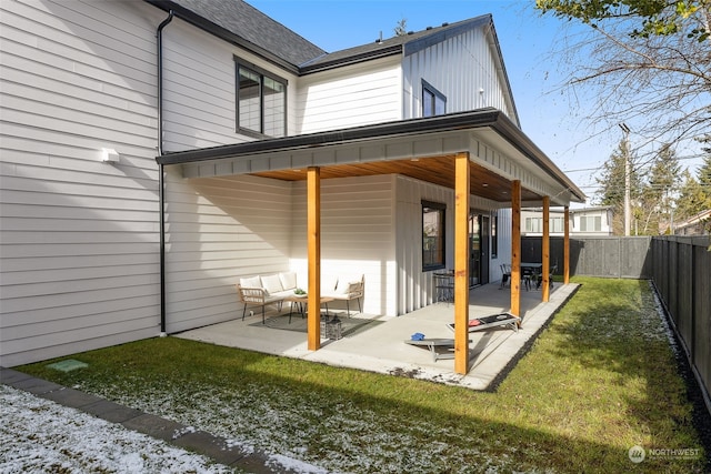 rear view of property featuring outdoor lounge area, a patio area, and a lawn