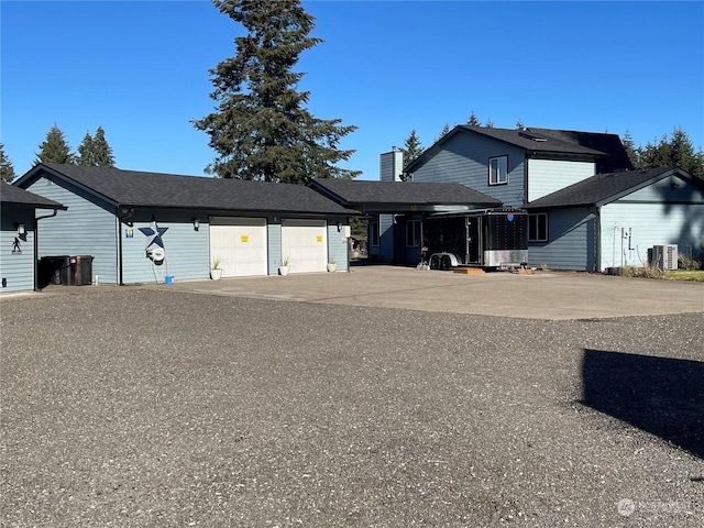 view of front of house with a garage and central air condition unit